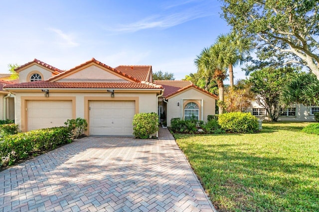 mediterranean / spanish-style house with a garage and a front yard