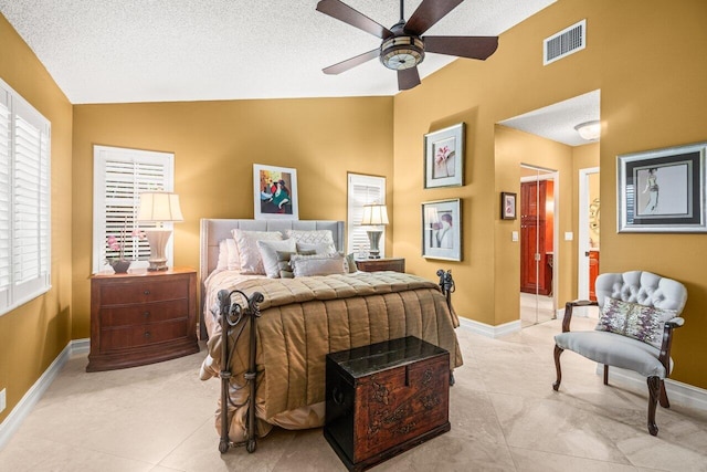 tiled bedroom with vaulted ceiling, connected bathroom, ceiling fan, and a textured ceiling