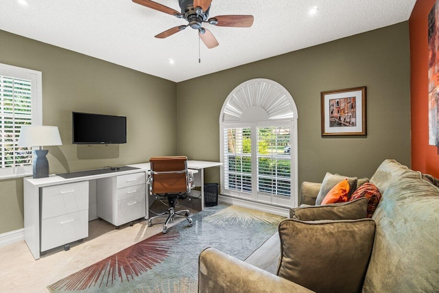 home office featuring a textured ceiling, ceiling fan, and light tile patterned flooring