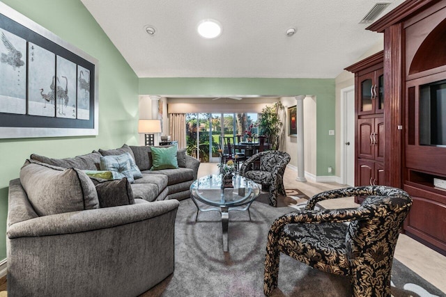 living room featuring decorative columns and lofted ceiling