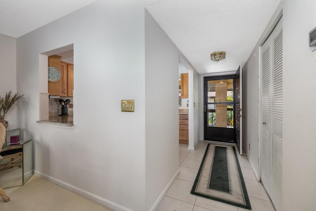 hallway with light tile patterned flooring and a textured ceiling