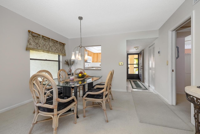 carpeted dining space with a healthy amount of sunlight and a textured ceiling