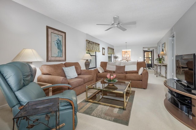 living room featuring ceiling fan, carpet, and a textured ceiling