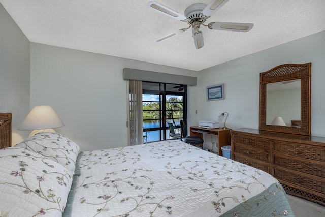 bedroom with access to exterior, a textured ceiling, and ceiling fan