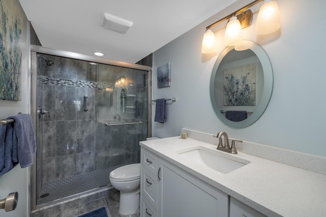 bathroom with vanity, a shower with shower door, and toilet