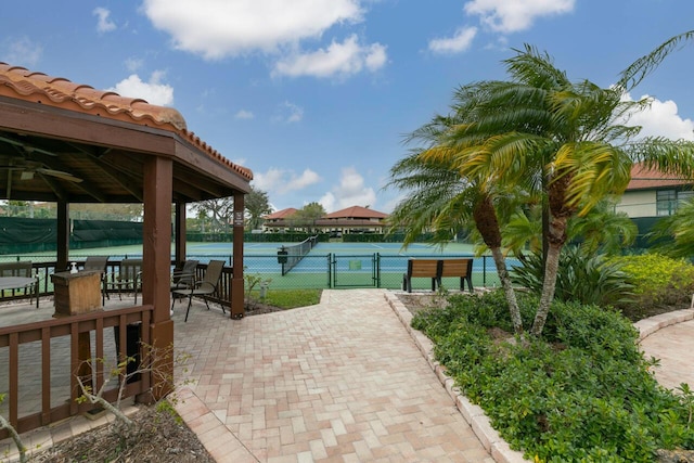 view of home's community featuring tennis court and a water view