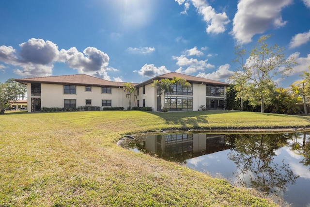 back of property featuring a water view and a yard