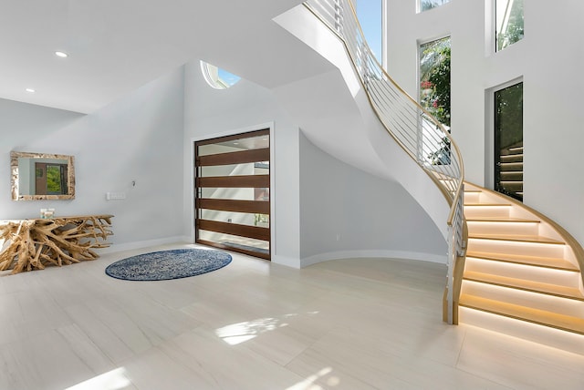 foyer featuring light tile patterned flooring and a high ceiling