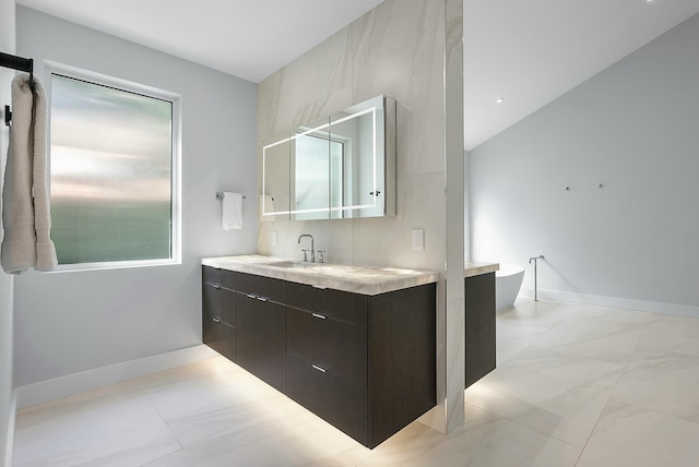 bathroom featuring lofted ceiling, vanity, and a bathtub