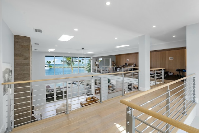 hallway featuring light wood-type flooring and a water view