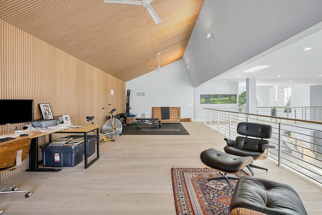 office featuring high vaulted ceiling, light hardwood / wood-style floors, and wood walls