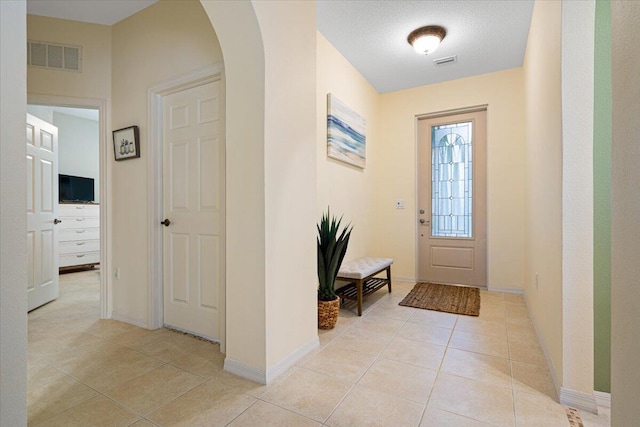 foyer featuring a textured ceiling and light tile patterned floors