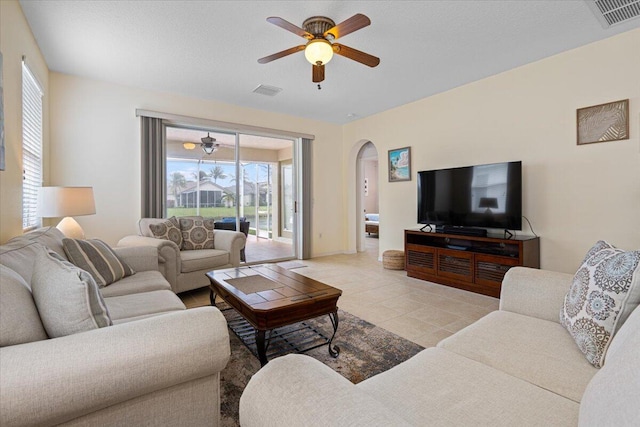 tiled living room featuring plenty of natural light and ceiling fan