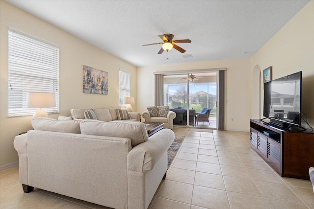 tiled living room featuring ceiling fan and a textured ceiling