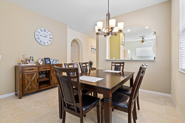 dining space featuring light tile patterned floors, a notable chandelier, and a textured ceiling