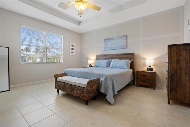 bedroom with a tray ceiling, ceiling fan, and light tile patterned flooring