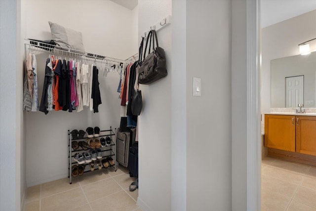 walk in closet with sink and light tile patterned floors