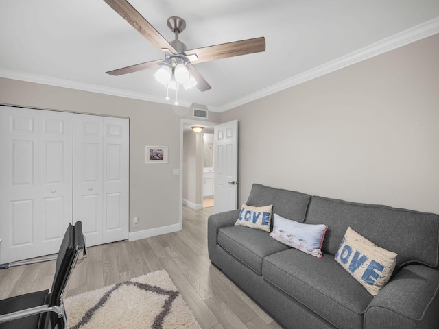 living room featuring ceiling fan, ornamental molding, and light hardwood / wood-style floors