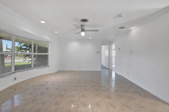 empty room with ornamental molding, light tile patterned flooring, a ceiling fan, and baseboards