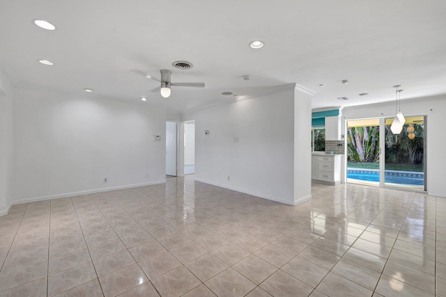 spare room featuring light tile patterned flooring, ceiling fan, and crown molding