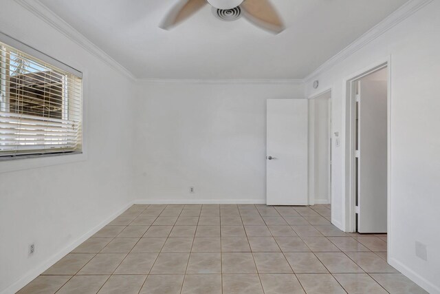 tiled empty room featuring crown molding and ceiling fan