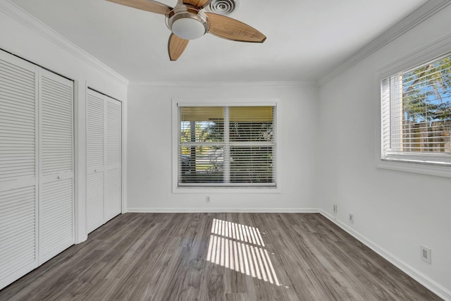 unfurnished bedroom featuring baseboards, ornamental molding, and wood finished floors