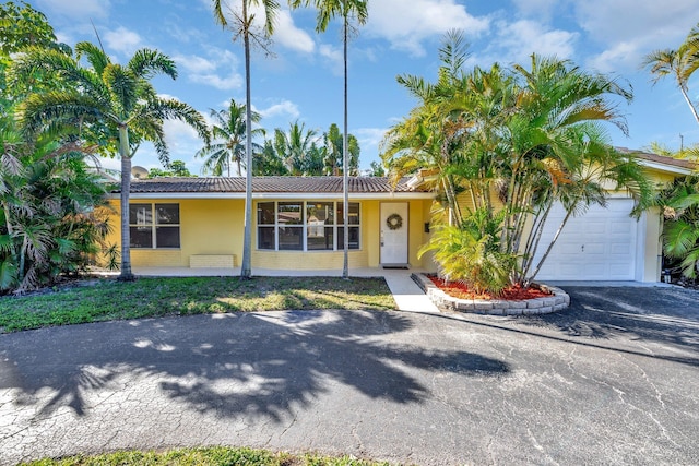 5801 NE 17th Ave, Fort Lauderdale, FL 33334 - view of front of home with a tile roof, driveway, a garage, and stucco siding