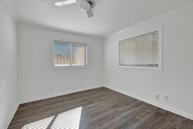 empty room with ornamental molding, wood finished floors, and baseboards