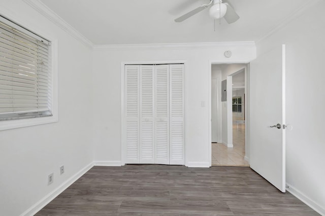 unfurnished bedroom featuring baseboards, a closet, ornamental molding, and wood finished floors