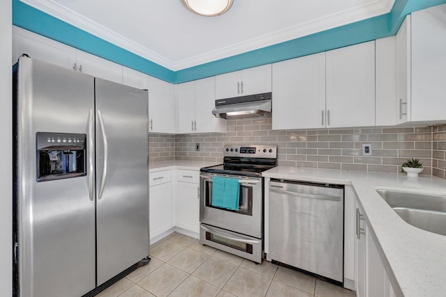 kitchen featuring stainless steel appliances, light tile patterned floors, white cabinets, and backsplash