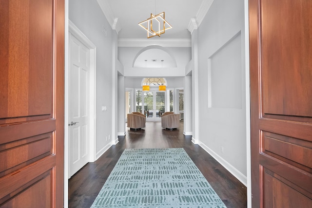 foyer entrance featuring ornamental molding, dark hardwood / wood-style floors, and a chandelier