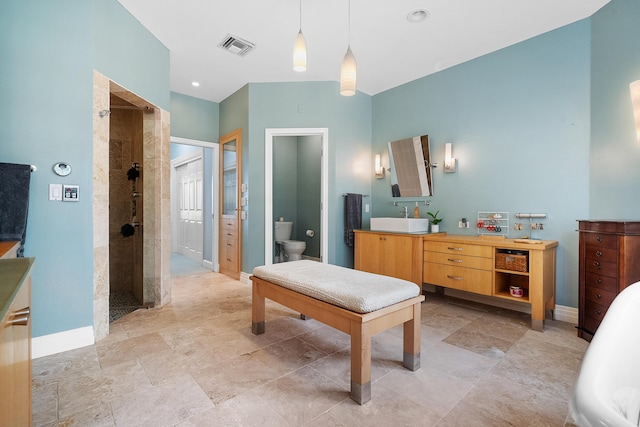 bathroom featuring vanity, toilet, and a tile shower