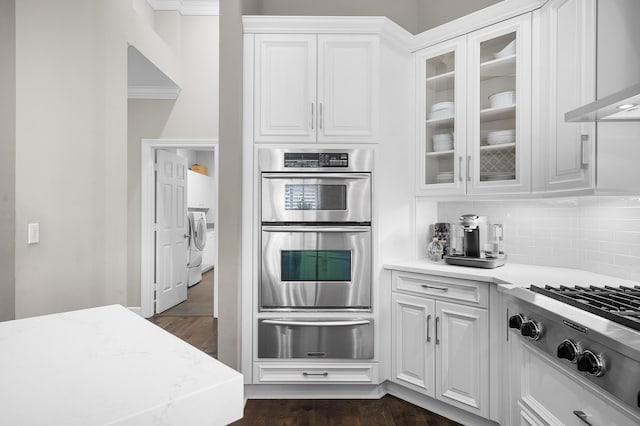 kitchen with white cabinets, decorative backsplash, stainless steel appliances, light stone countertops, and wall chimney exhaust hood