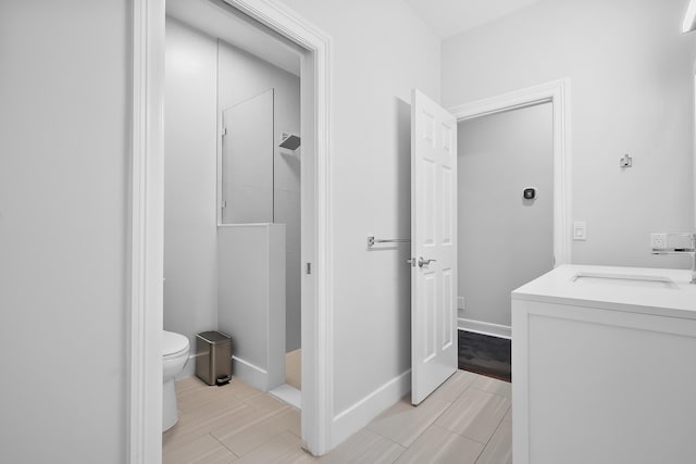 bathroom with a shower, vanity, and toilet