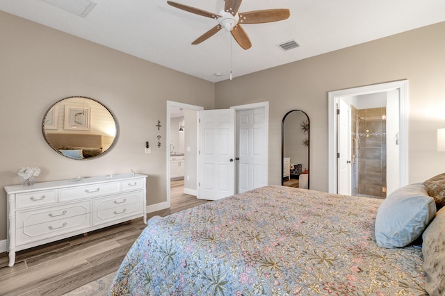 bedroom with ceiling fan, ensuite bath, and light hardwood / wood-style flooring