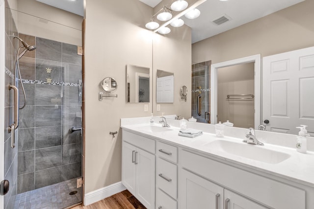 bathroom with hardwood / wood-style flooring, vanity, and walk in shower