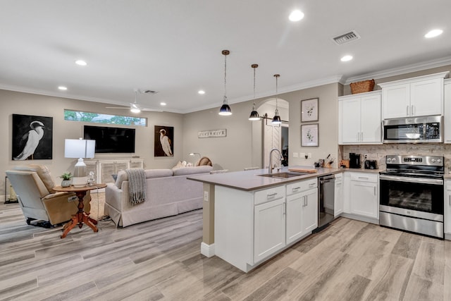 kitchen featuring decorative light fixtures, a barn door, white cabinets, and appliances with stainless steel finishes