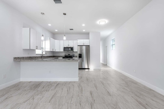 kitchen with stone countertops, hanging light fixtures, kitchen peninsula, stainless steel appliances, and white cabinets