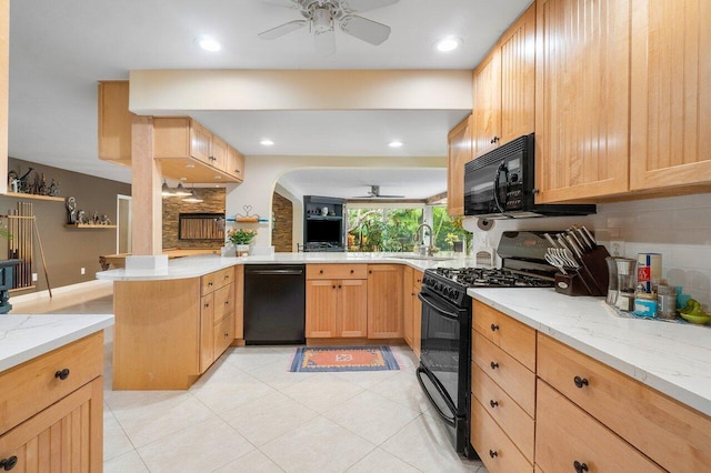 kitchen with tasteful backsplash, kitchen peninsula, sink, and black appliances