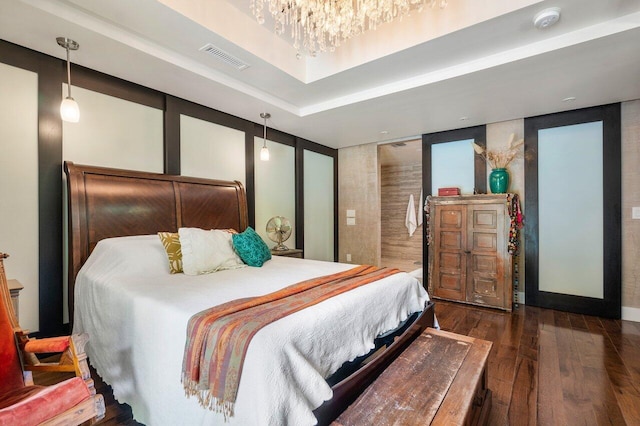 bedroom featuring a chandelier, dark hardwood / wood-style flooring, and a tray ceiling