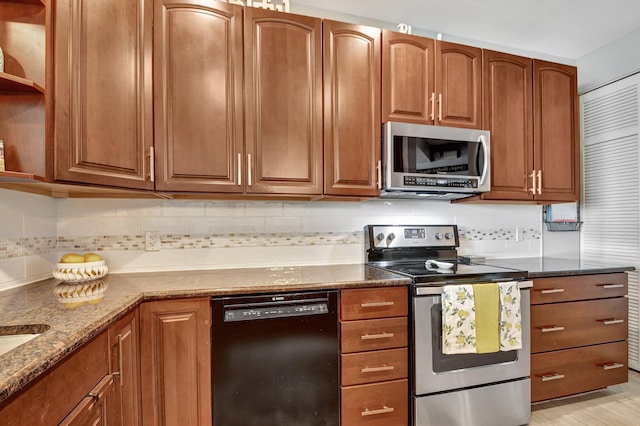 kitchen featuring tasteful backsplash, light stone countertops, and stainless steel appliances