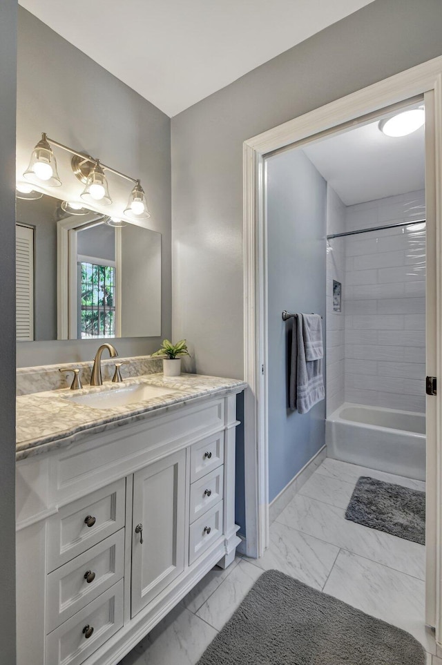 bathroom featuring tiled shower / bath combo and vanity