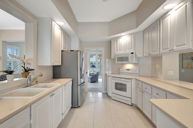 kitchen with light tile patterned flooring, sink, white cabinetry, ornamental molding, and white appliances