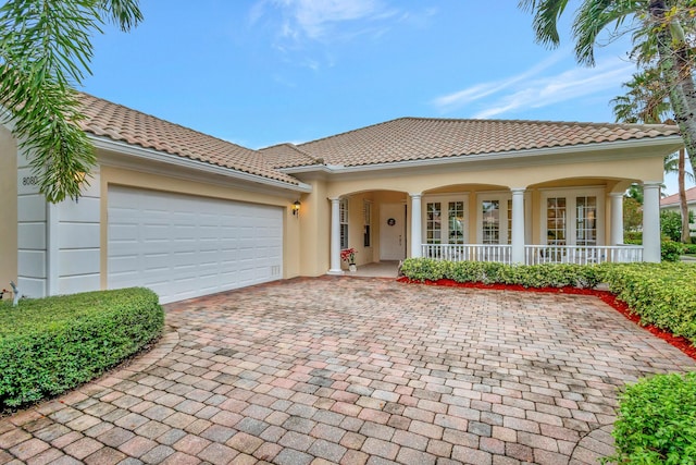 mediterranean / spanish-style home with a garage and a porch