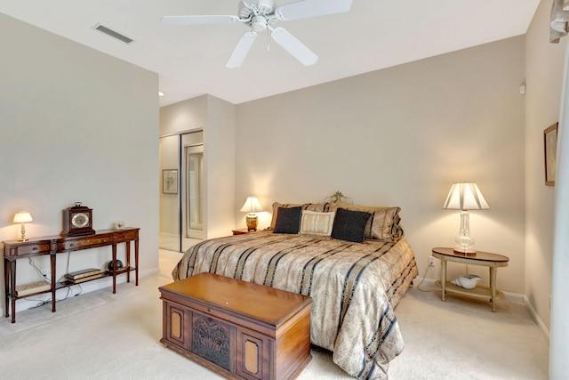 bedroom featuring light colored carpet, ceiling fan, and a closet