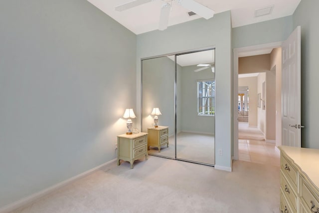 carpeted bedroom featuring ceiling fan and a closet