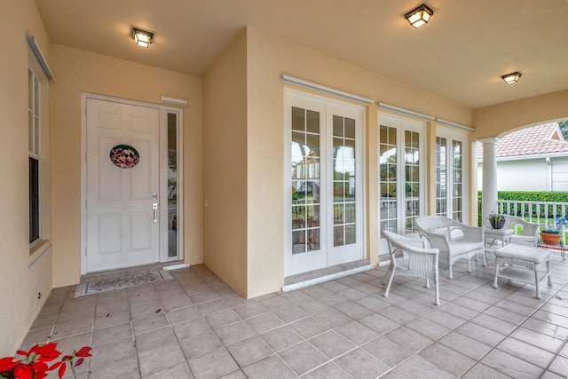 view of exterior entry featuring a patio area and french doors