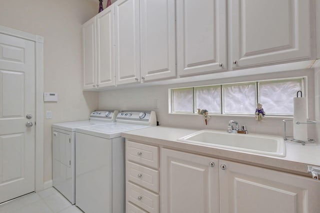 laundry area featuring cabinets, light tile patterned floors, sink, and washing machine and clothes dryer