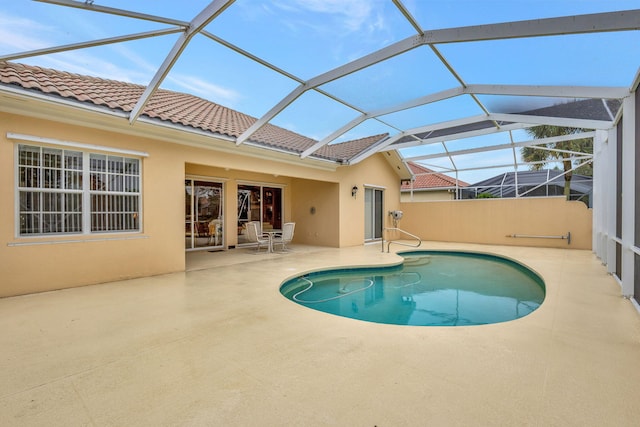 view of swimming pool with glass enclosure and a patio area