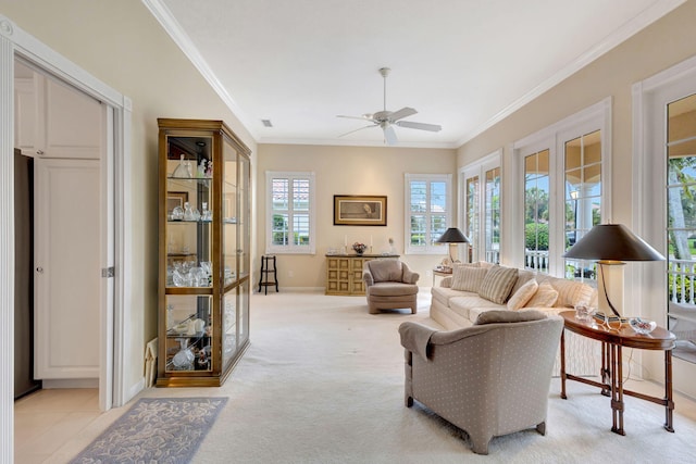 living room featuring crown molding, light colored carpet, and ceiling fan